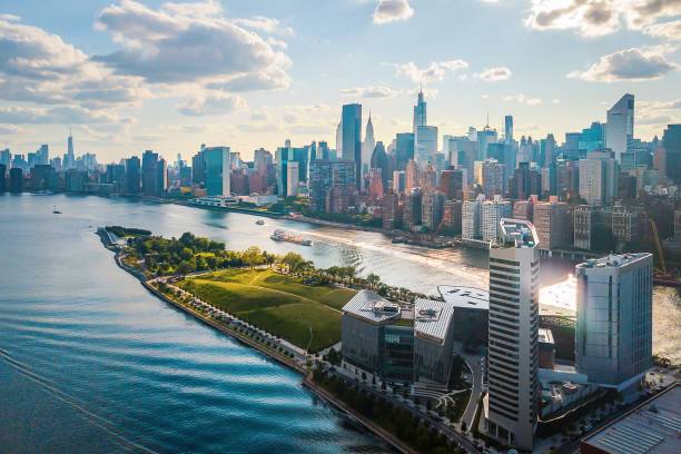 Aerial view of a city skyline with a river and park in the foreground.