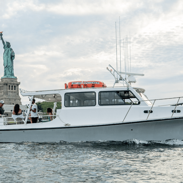 Boat in water with Statue of Liberty in background.