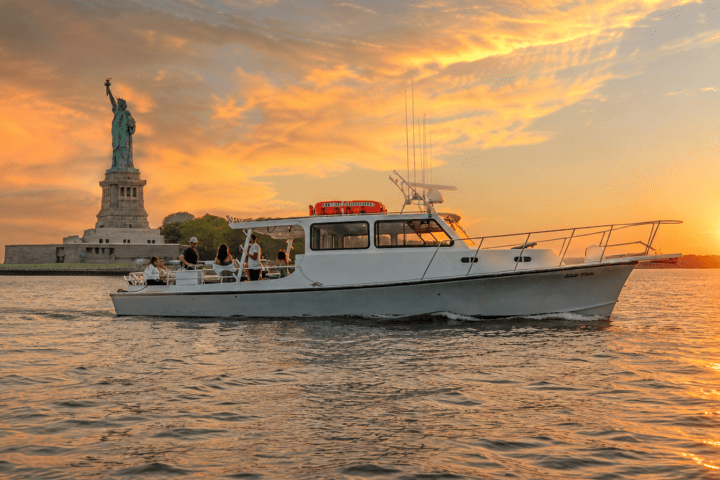 Boat on water near the Statue of Liberty at sunset.